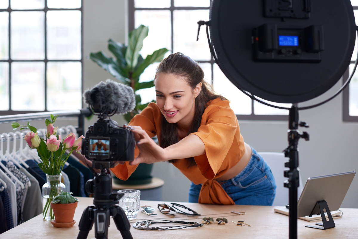 Young female vlogger adjusting her video equipment to record for her lifestyle fashion channel